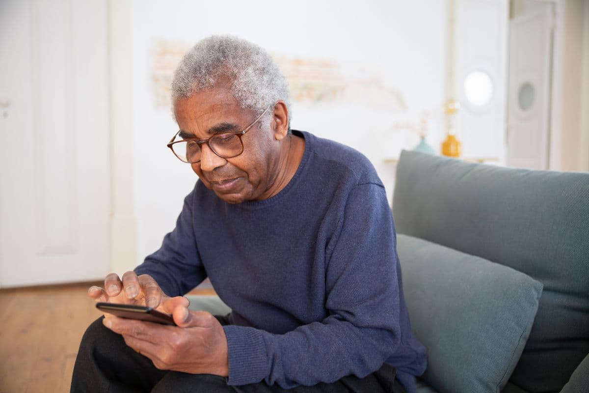 Older adult at home staying connected to everyday life with practical support nearby